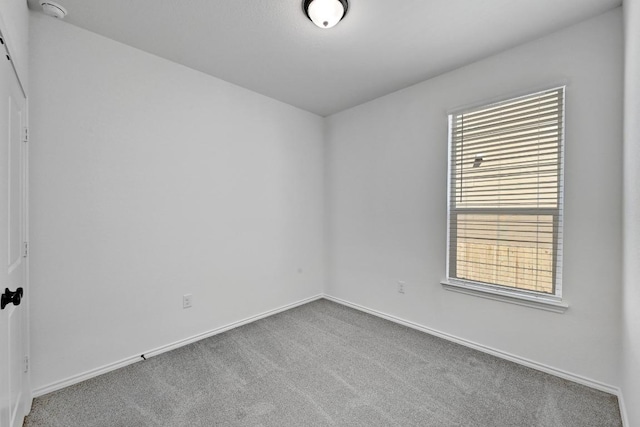 carpeted spare room with baseboards