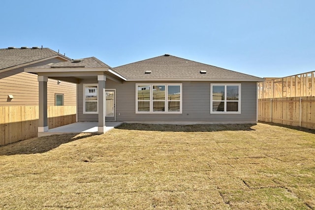 back of house with a yard, a patio, a shingled roof, and fence