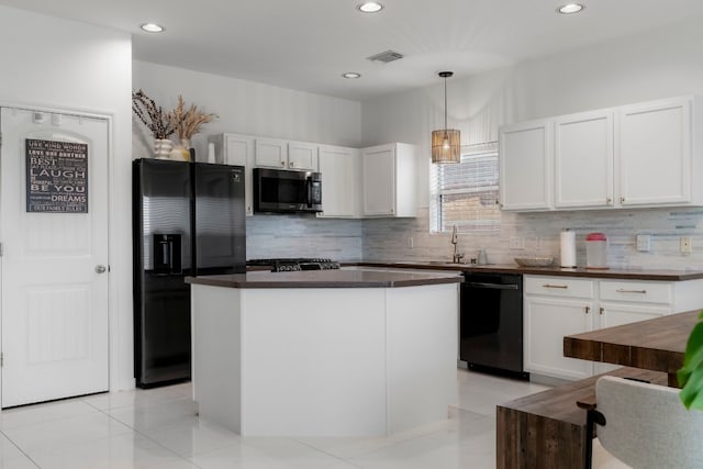 kitchen featuring a center island, sink, decorative light fixtures, white cabinets, and black appliances