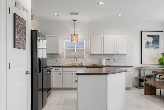 kitchen with decorative backsplash, white cabinetry, hanging light fixtures, and sink