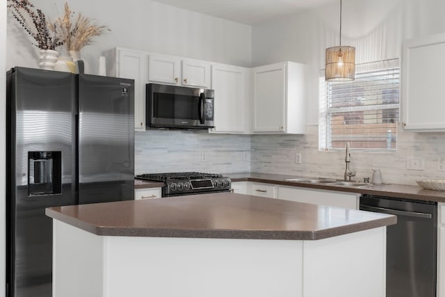 kitchen featuring appliances with stainless steel finishes, tasteful backsplash, sink, decorative light fixtures, and white cabinetry