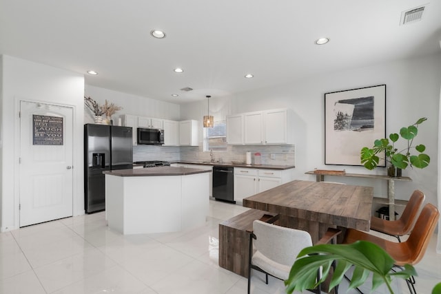 kitchen featuring a center island, tasteful backsplash, pendant lighting, white cabinets, and black appliances