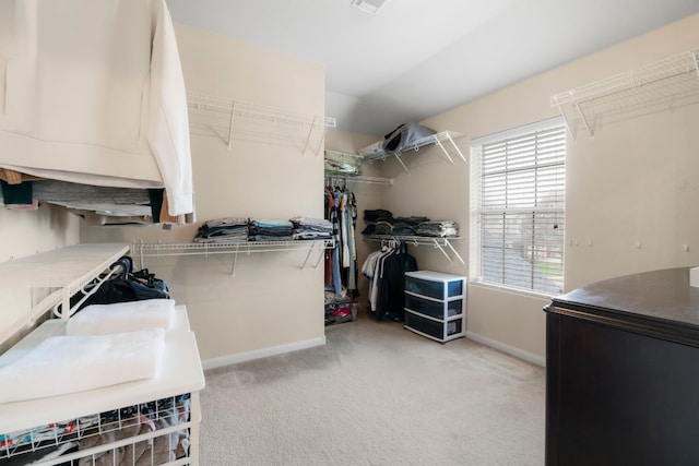 walk in closet featuring light carpet