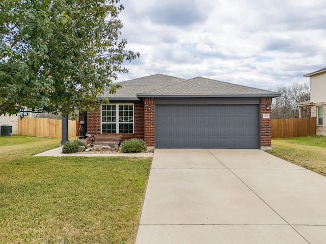 view of front of home with a front yard, central AC, and a garage