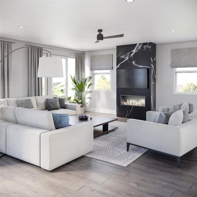 living room with ceiling fan, wood-type flooring, and a fireplace