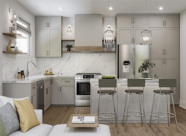 kitchen featuring appliances with stainless steel finishes, backsplash, ventilation hood, sink, and decorative light fixtures