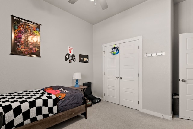 bedroom with ceiling fan, a closet, and light carpet