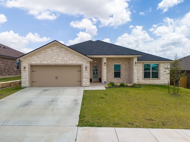 view of front of home with a front yard and a garage