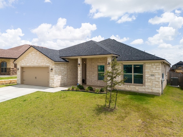 view of front of property with a front yard, central AC, and a garage