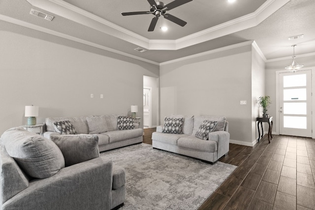 living room with a tray ceiling, ceiling fan, and ornamental molding