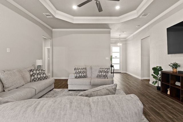 living room featuring ceiling fan with notable chandelier, dark hardwood / wood-style flooring, a raised ceiling, and crown molding