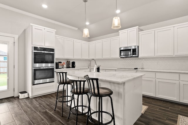 kitchen with a kitchen island with sink, white cabinets, and stainless steel appliances