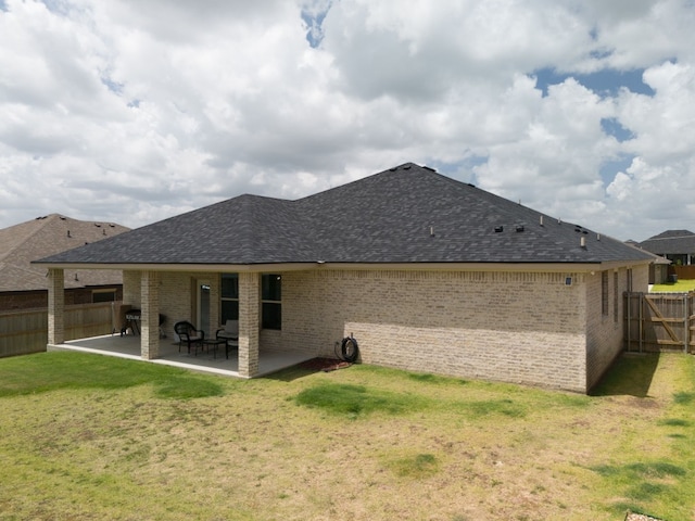 rear view of house with a yard and a patio