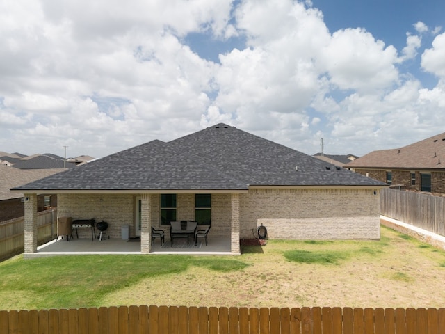 rear view of house with a lawn and a patio