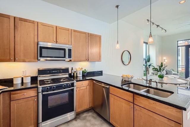 kitchen featuring decorative light fixtures, kitchen peninsula, appliances with stainless steel finishes, and sink