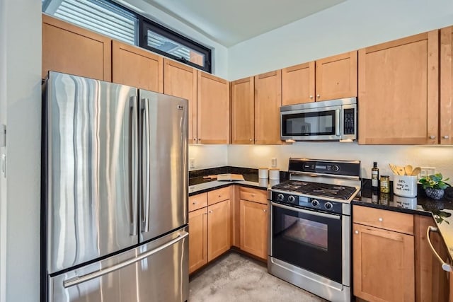 kitchen featuring appliances with stainless steel finishes and dark stone countertops