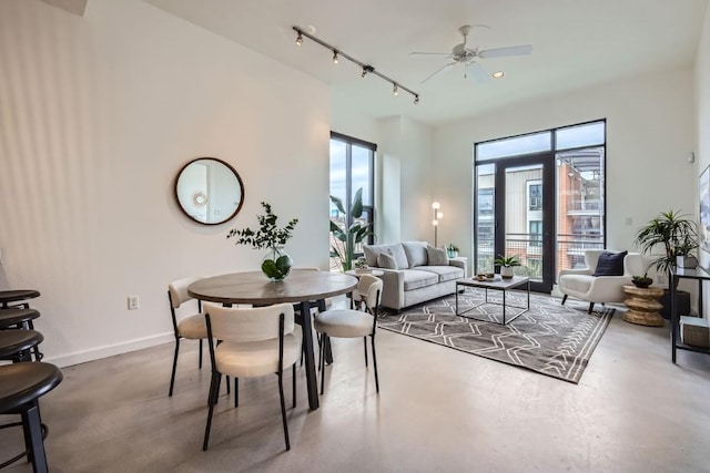 interior space with ceiling fan, concrete floors, and rail lighting