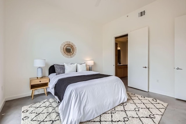 bedroom featuring concrete floors and ensuite bathroom