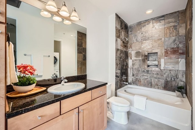 full bathroom featuring vanity, stacked washer / dryer, tiled shower / bath combo, and toilet