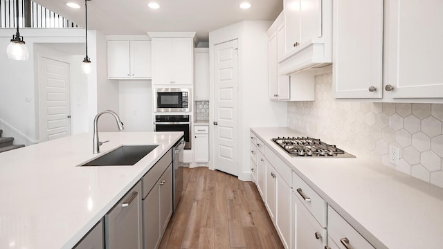 267 Carpenter Hill Dr, Buda, TX 78610 - kitchen featuring stainless steel appliances, light countertops, decorative light fixtures, light wood-type flooring, and recessed lighting