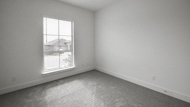 carpeted spare room with baseboards
