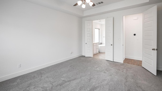 unfurnished bedroom with ensuite bathroom, visible vents, carpet floors, and baseboards