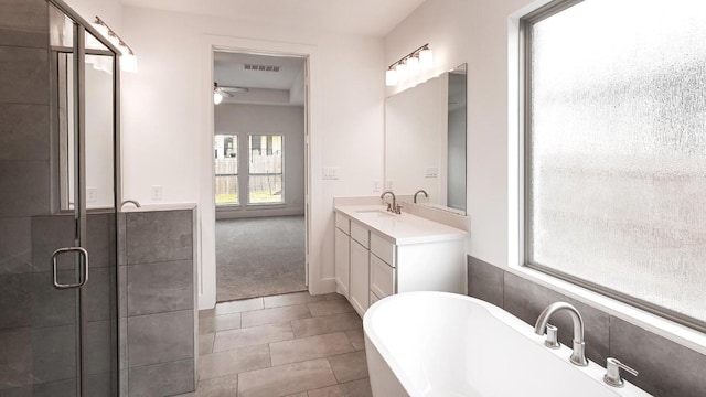 267 Carpenter Hill Dr, Buda, TX 78610 - full bathroom featuring a freestanding tub, vanity, ceiling fan, a shower stall, and tile patterned flooring