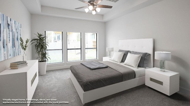 carpeted bedroom featuring ceiling fan and a tray ceiling