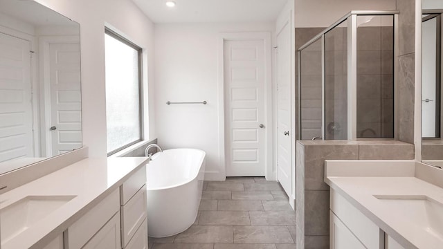 267 Carpenter Hill Dr, Buda, TX 78610 - bathroom with healthy amount of natural light, a shower stall, two vanities, a freestanding bath, and recessed lighting