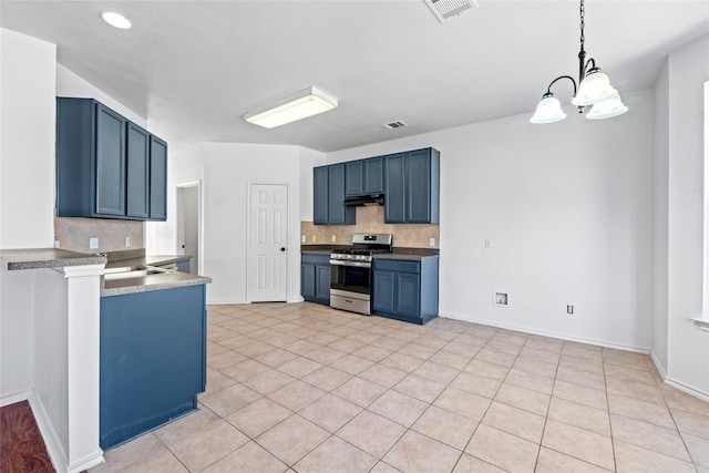 kitchen featuring blue cabinets, backsplash, hanging light fixtures, and gas range