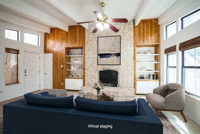 tiled living room with beam ceiling, wooden walls, ceiling fan, and a high ceiling