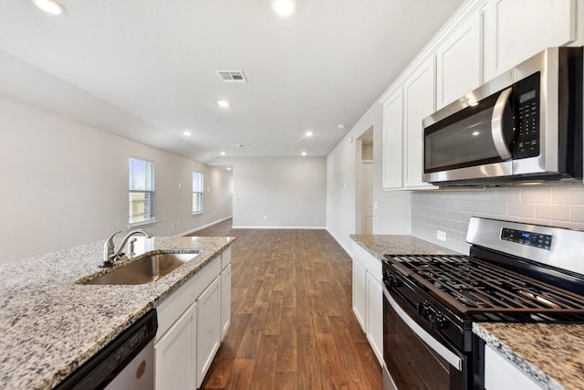 kitchen with light stone counters, white cabinetry, sink, and appliances with stainless steel finishes