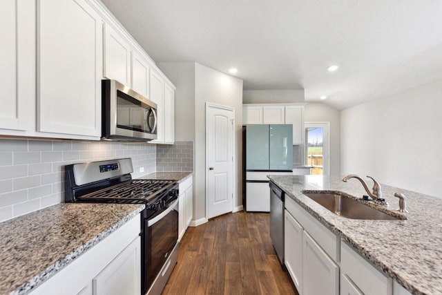 kitchen featuring white cabinetry, sink, light stone counters, and appliances with stainless steel finishes