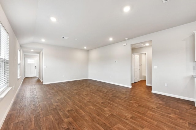 spare room featuring dark hardwood / wood-style flooring and lofted ceiling