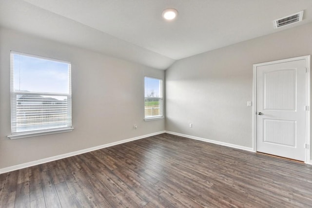 empty room featuring dark hardwood / wood-style floors and lofted ceiling