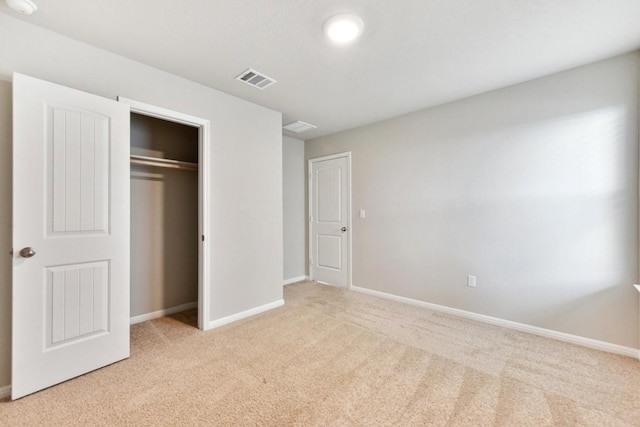 unfurnished bedroom featuring a closet and light colored carpet