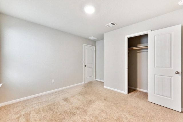 unfurnished bedroom with light carpet and a closet