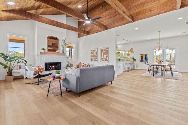 living room with beam ceiling, ceiling fan with notable chandelier, high vaulted ceiling, and plenty of natural light