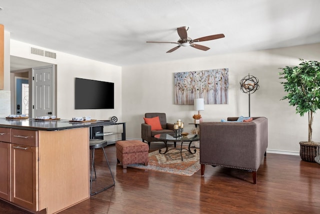 living room featuring ceiling fan and dark wood-type flooring