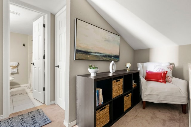 carpeted bedroom featuring ensuite bathroom and lofted ceiling