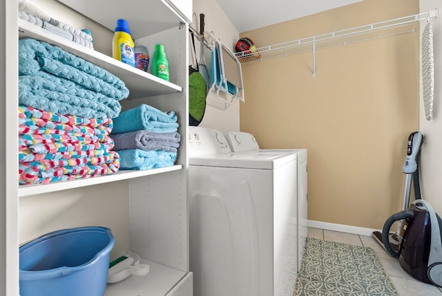 clothes washing area with washer and clothes dryer and light tile patterned floors