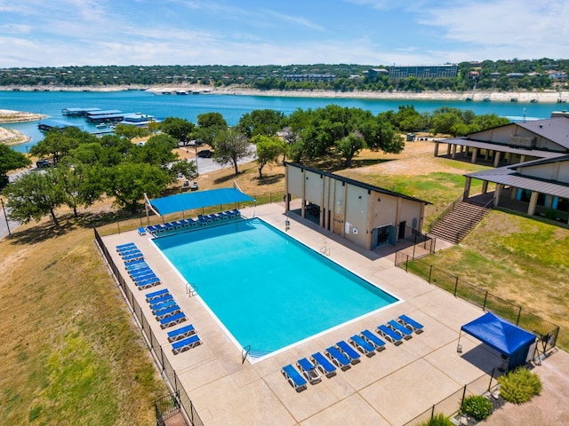 view of swimming pool featuring a water view and a yard