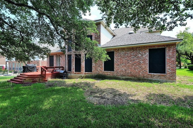 rear view of property with a lawn and a wooden deck