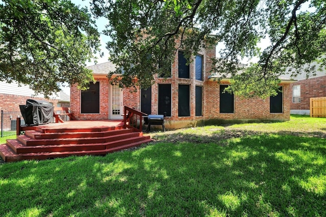 back of property with a wooden deck and a lawn