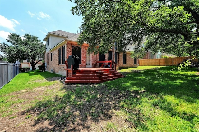 rear view of house with a lawn and a wooden deck