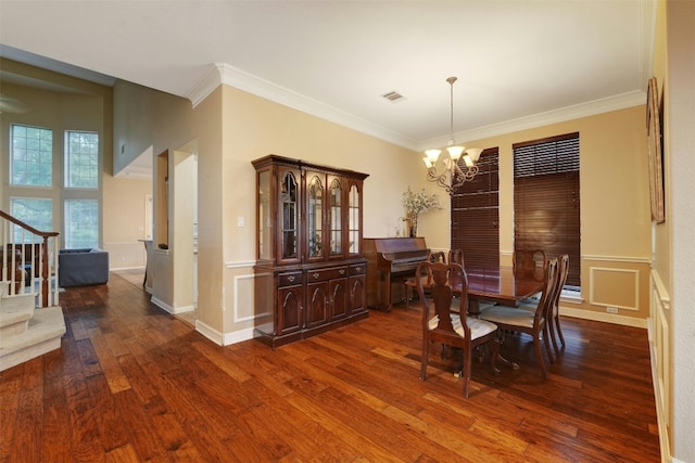 dining area featuring crown molding, dark hardwood / wood-style floors, and an inviting chandelier