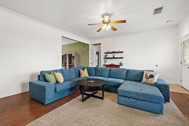 living room with wood-type flooring, ceiling fan, and crown molding