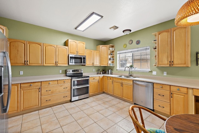 kitchen with sink, light tile patterned floors, stainless steel appliances, and light brown cabinetry