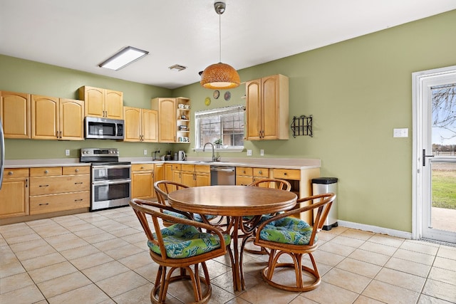 kitchen with decorative light fixtures, light brown cabinets, light tile patterned floors, and stainless steel appliances