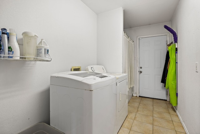 laundry room featuring washer and dryer and light tile patterned flooring